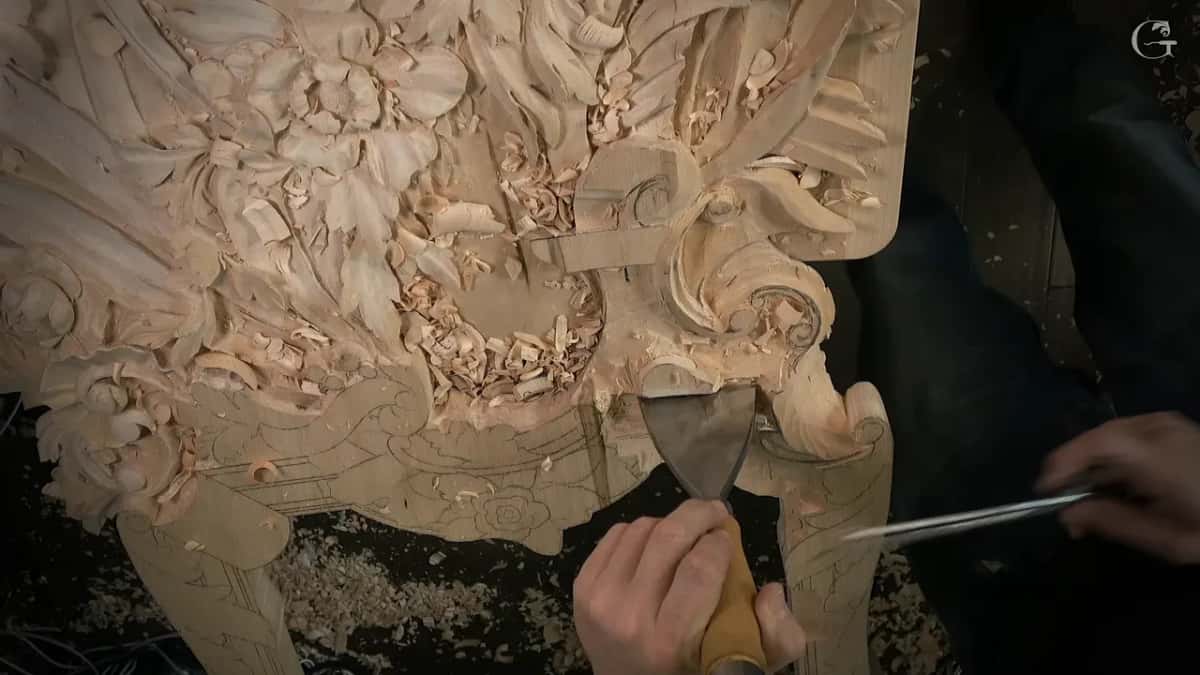 Wide flat chisel upright on a line while the other hand brings in a thin pair of calipers