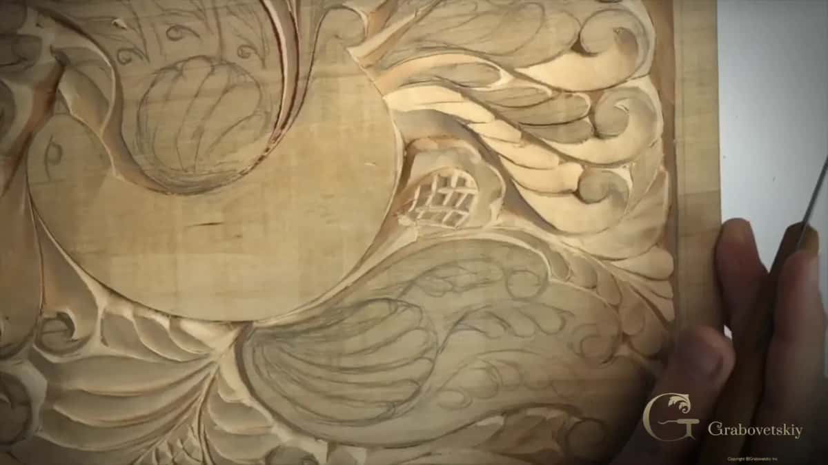 Close view of carved leaves and my fist holding the knife against the right border