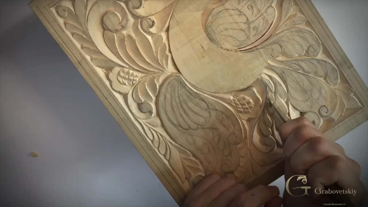 Tilted board, my right hand working a leaf near its lower right corner