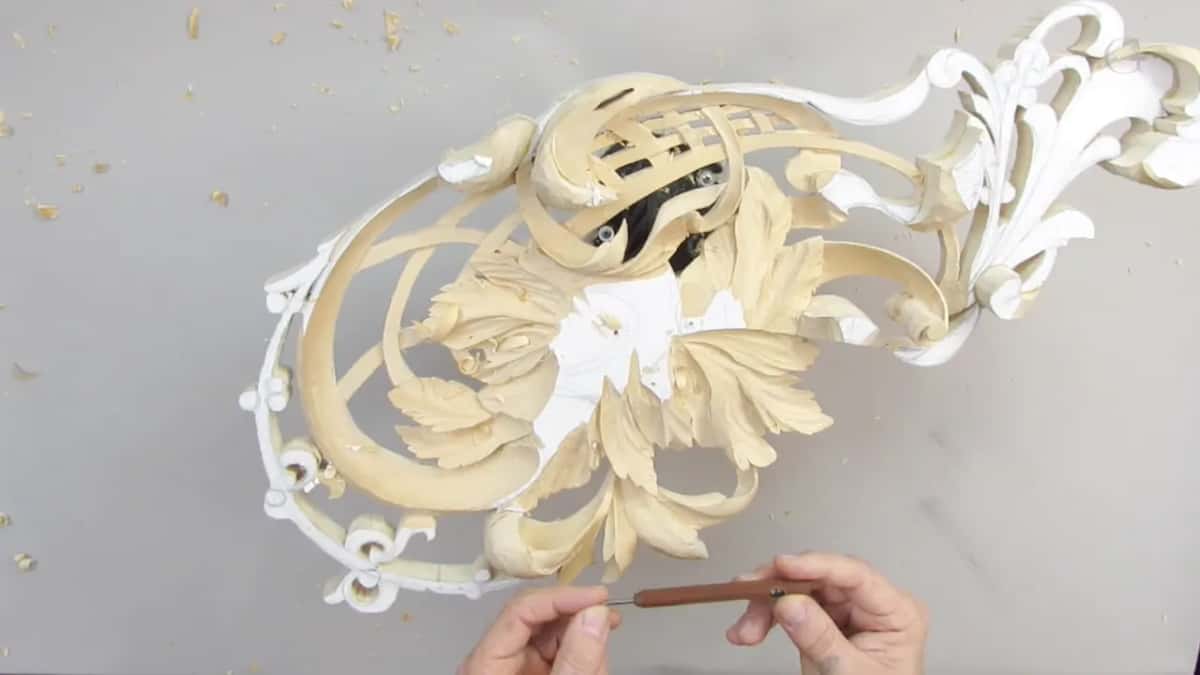 Whole panel from above, a brown handled tool held in both hands below it