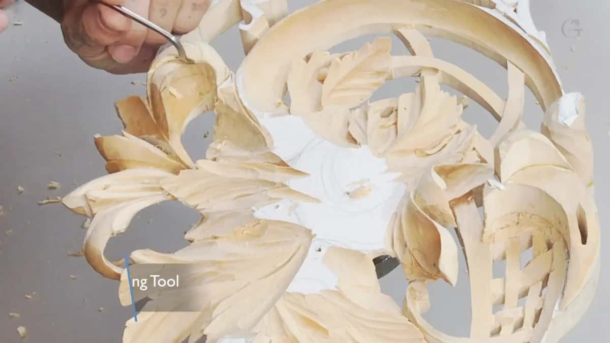 My hand at the top left holding a small bent tool over the panel