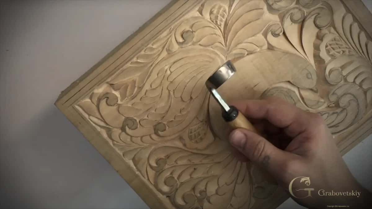 Bent spoon carving tool held over the board