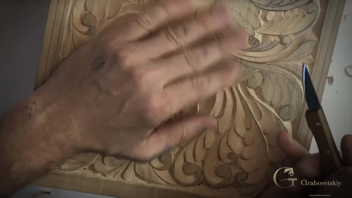 A blurred hand flat over the carved wing