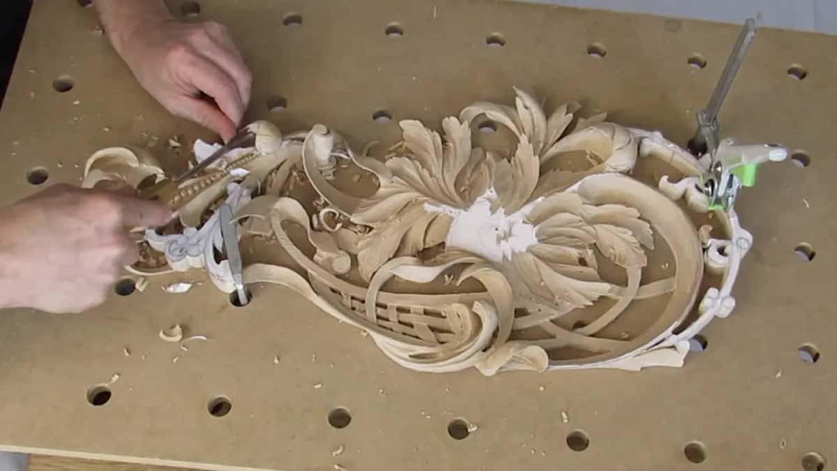 Both hands are busy at the left end of the panel while a clamp holds the far right end