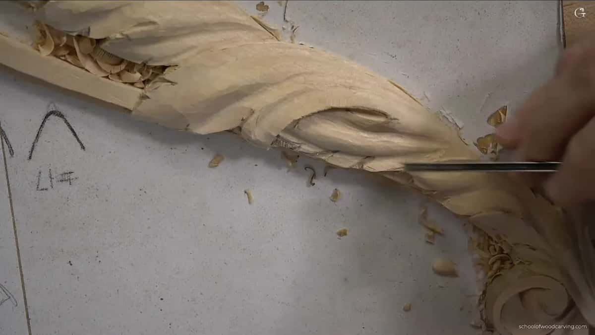 A gouge works the leaf while chips fill the molding channel next to it