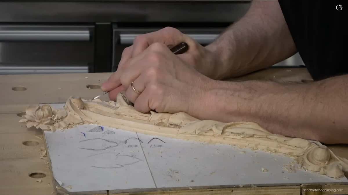 Both hands low over the piece