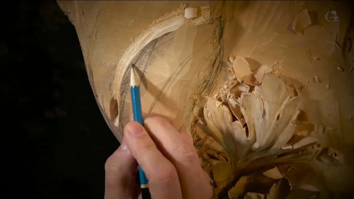 Arc in the hollow One blue pencil marking an arc inside a hollow, shavings piled to the right, black behind all of it