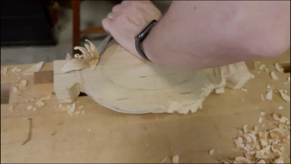 Fresh chips curling up at the far block as a forearm crosses the tray