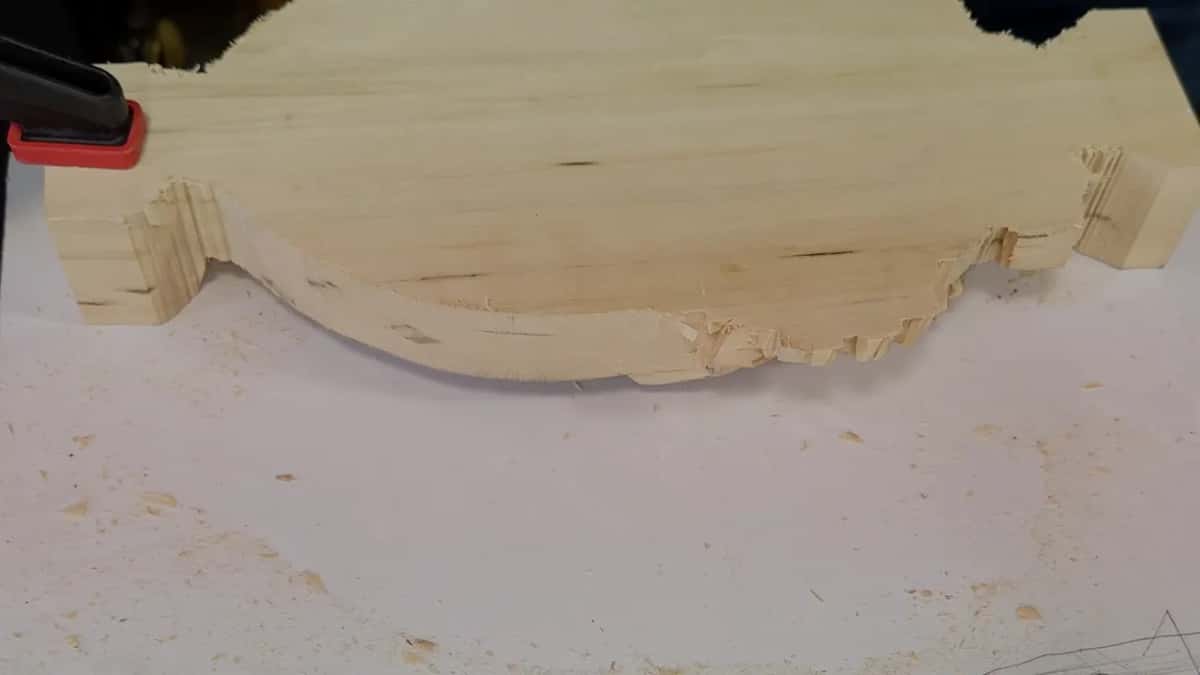 Tray lying upside down on white paper with a red clamp holding one end