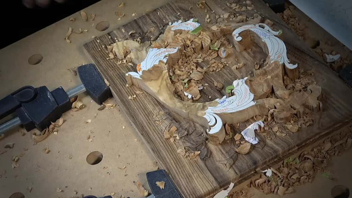 Dark-grained panel clamped flat, chips everywhere