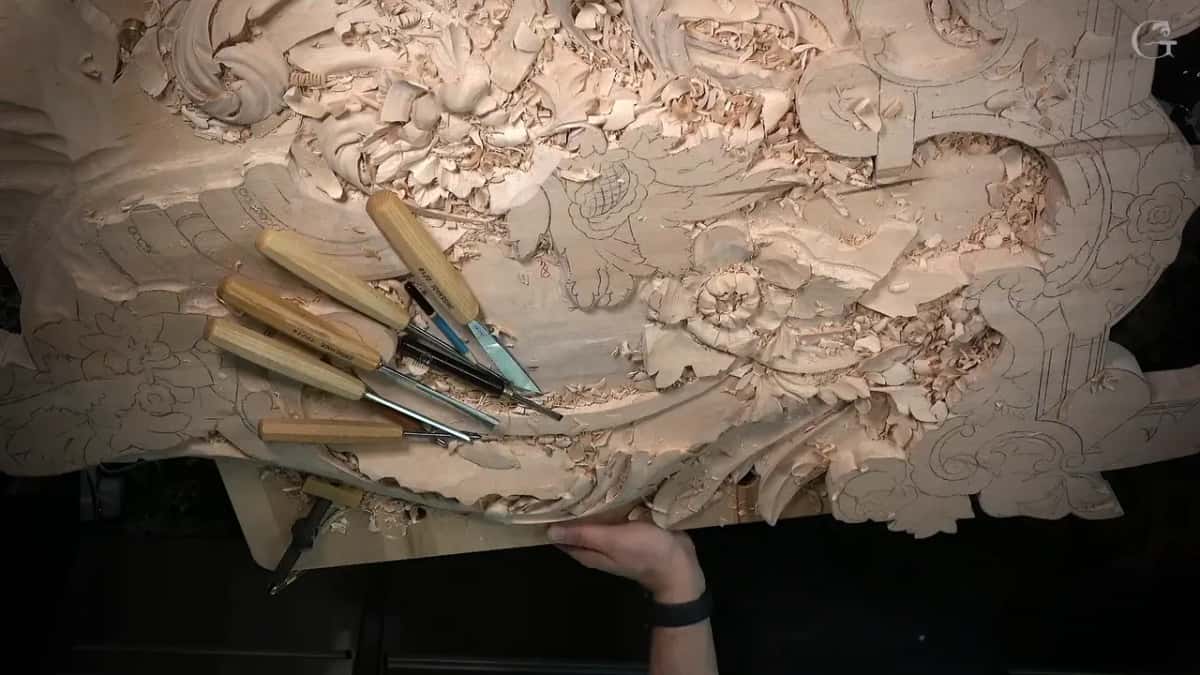Gouges lie in a heap on a busy carved panel