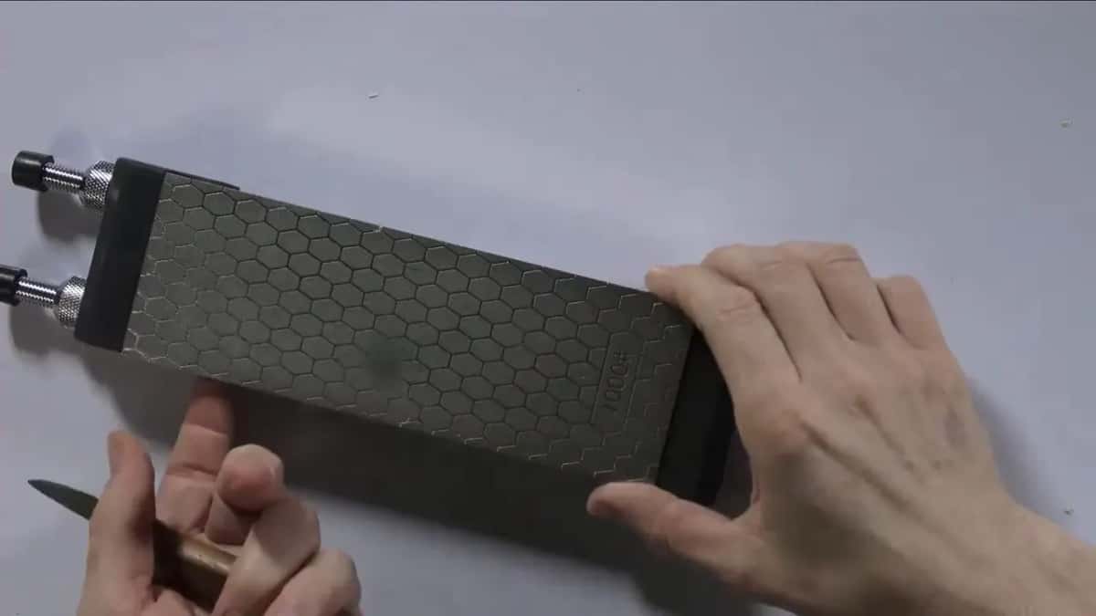 Honeycomb sharpening plate in a clamp, the knife laid against it
