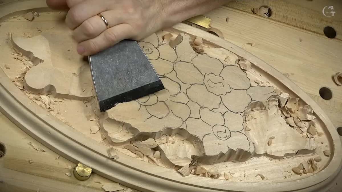 Flat chisel pressed against the drawn flowers, chips all around