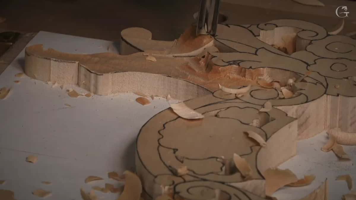 A gouge going straight down into the blank from above, shavings lying on the white paper around it