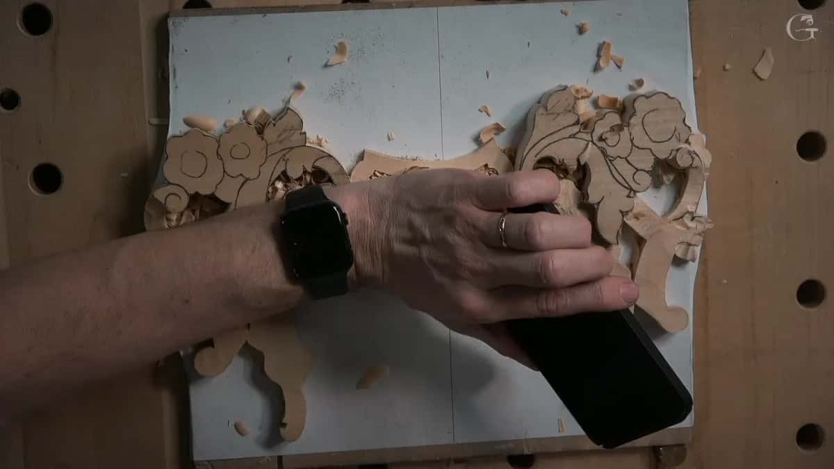A hand holds a black phone flat over the right half