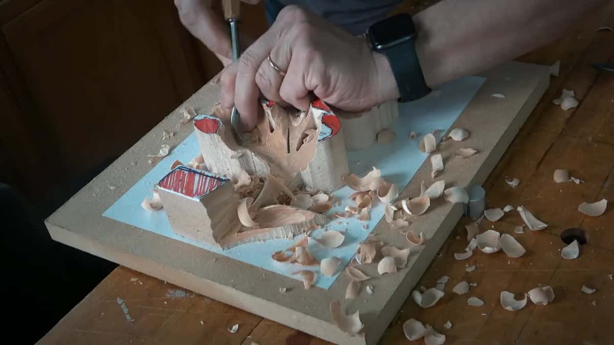 A right hand holds a slim tool upright inside the hollow
