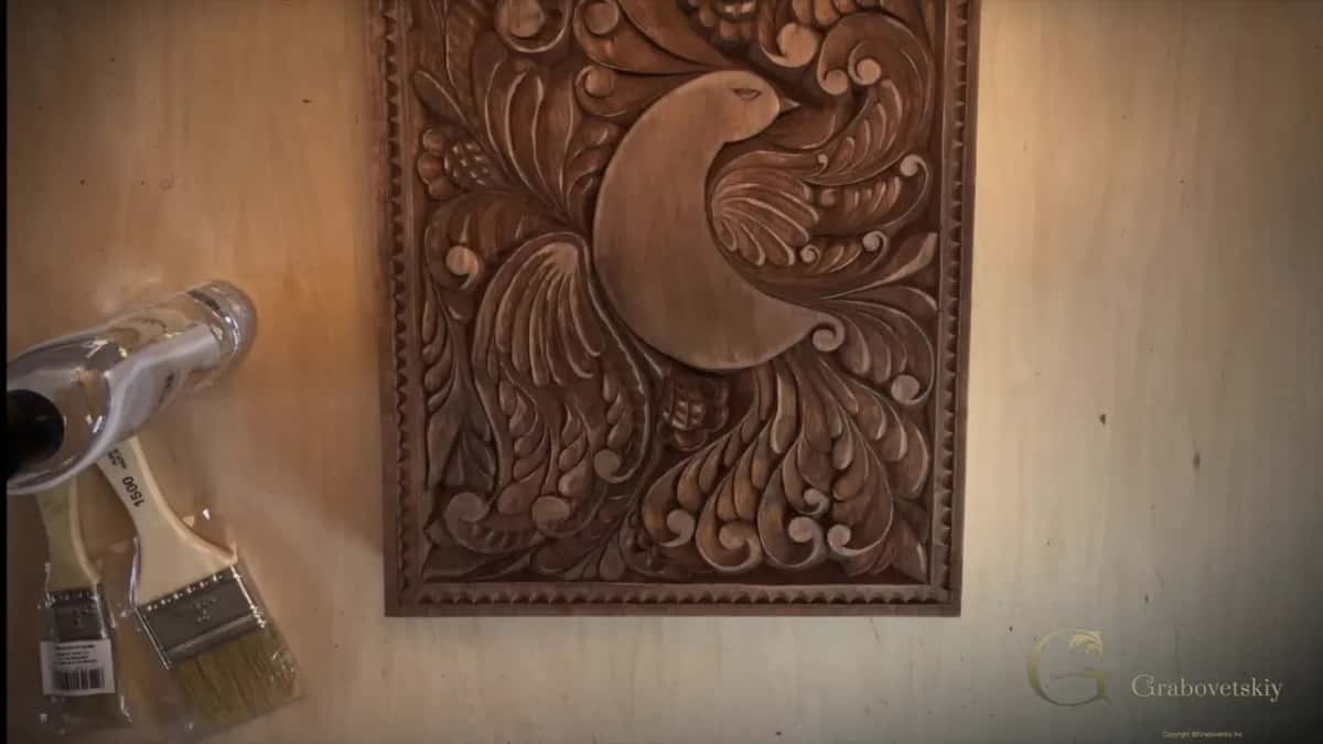 Stained board flat, two brushes and a bottle at its side