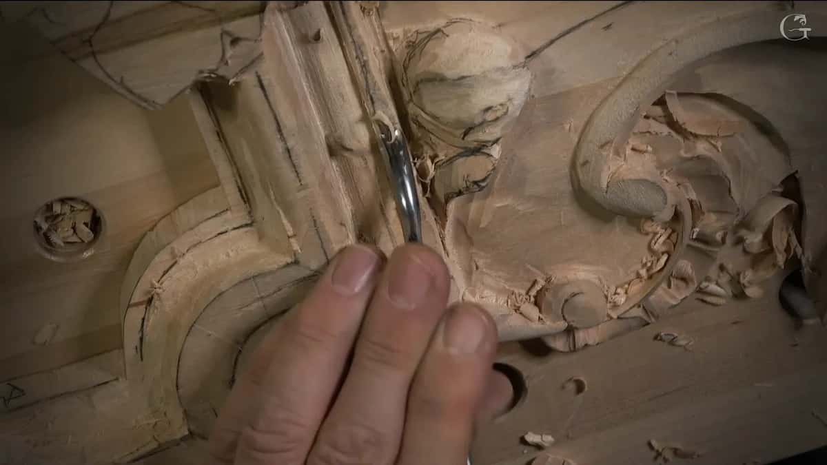 Back bent standing upright in the corner where the molding turns beside a carved volute