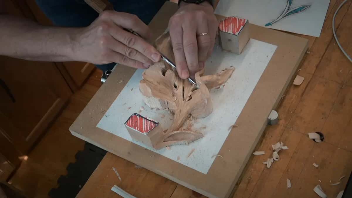 Two hands guide a slim tool into the leaf's middle
