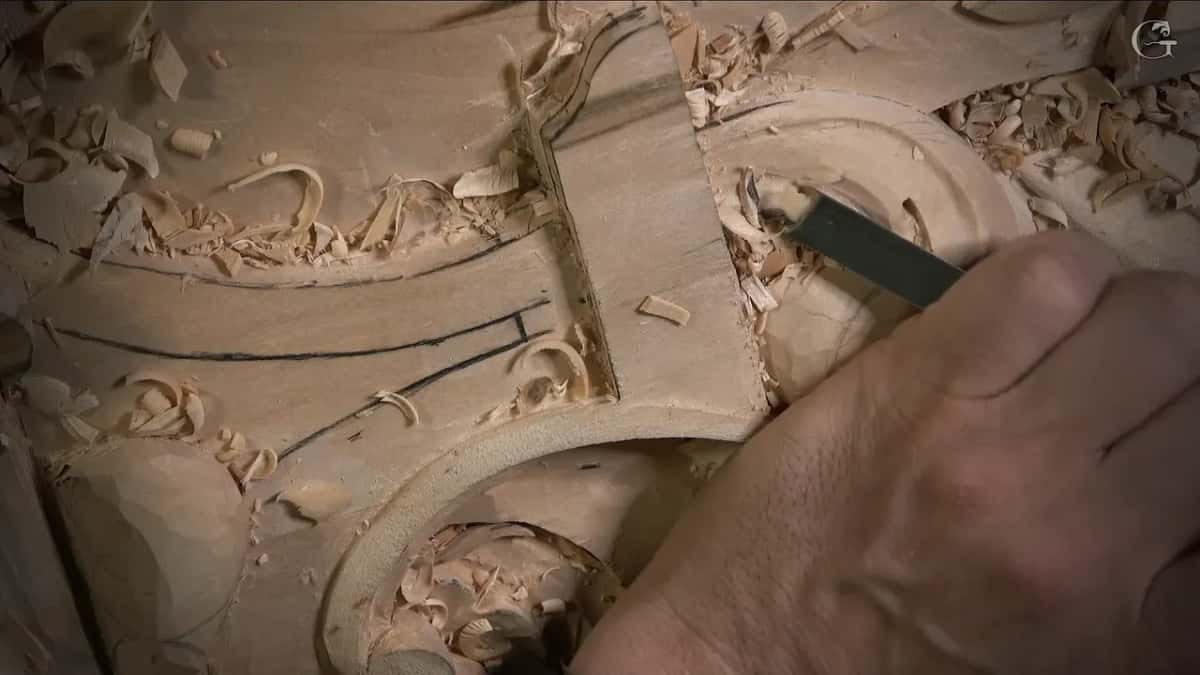 Chips pile up around a round hollow while a gouge works along its rim