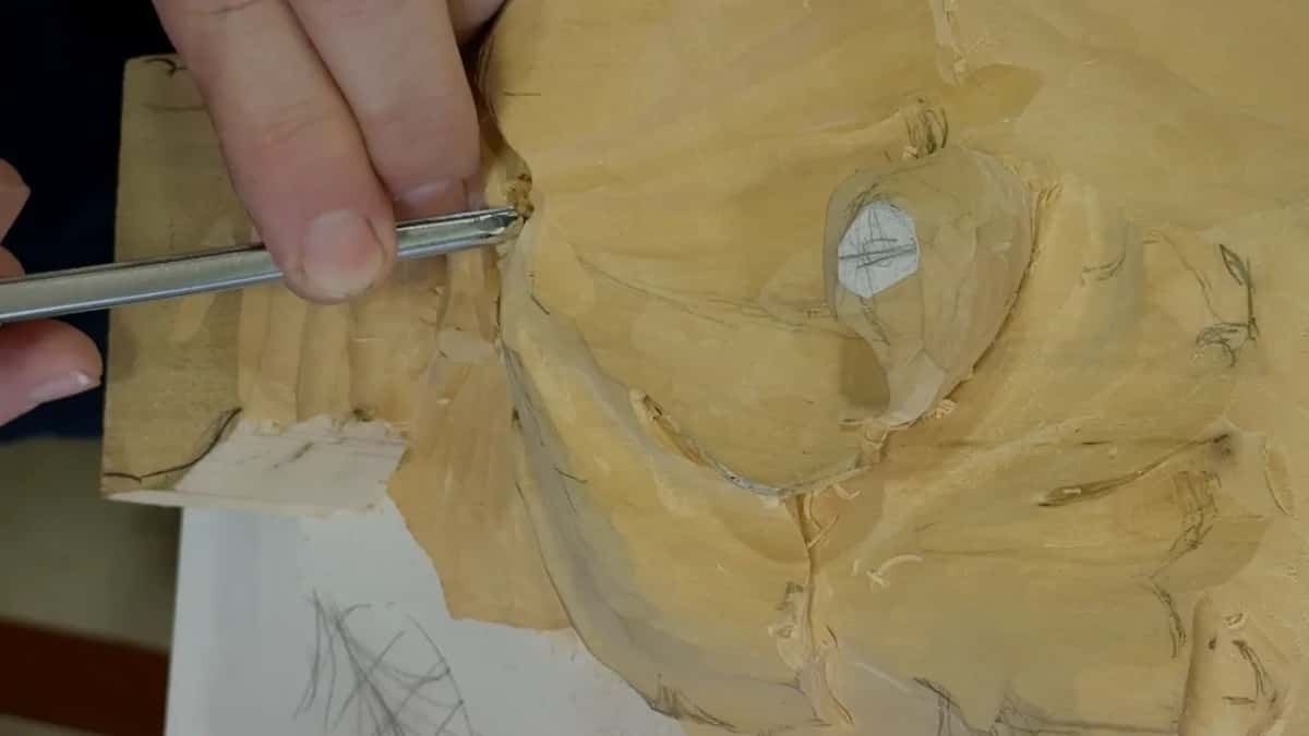 Working from the left with a slim gouge, right into the corner where the block and leaf meet