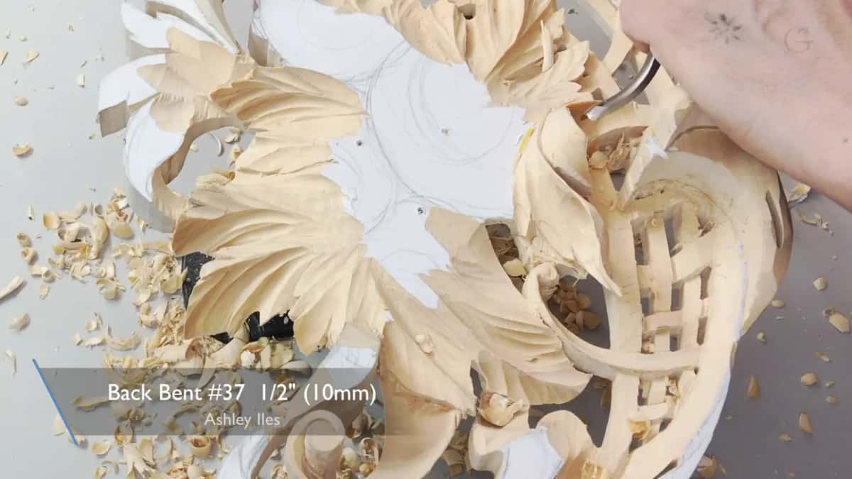 A caption reads Back Bent #37 as a hand works deep inside a pierced flower carving.