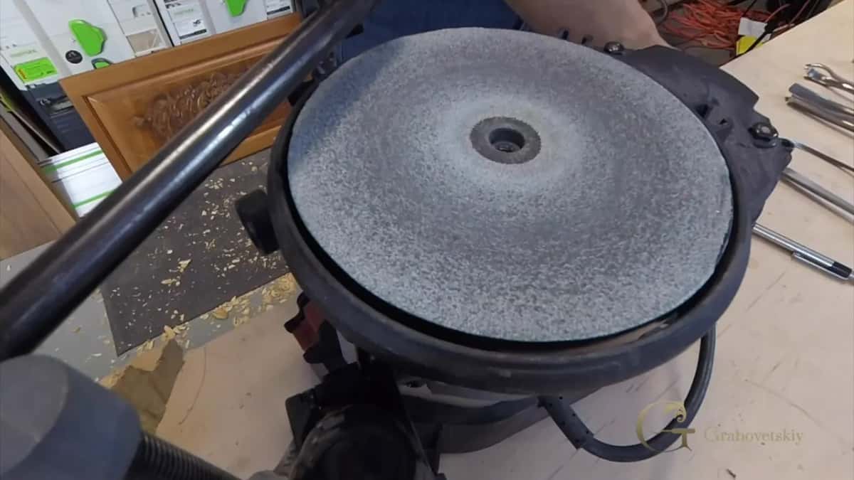 A grey abrasive disc on a flat machine.